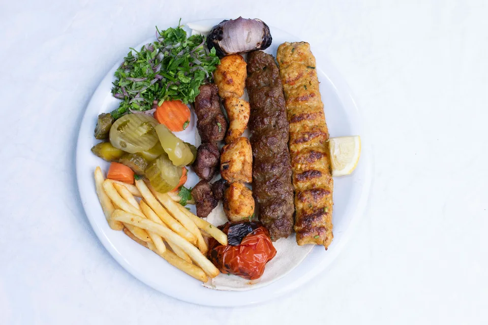 BookNoFees: Fotografie ilustrativă: Frigărui la grătar servite cu salată și cartofi prăjiți