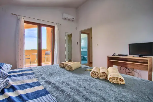 BookNoFees: cazare de vacanță în Štokovci, Croația – un dormitor cu un pat, prosoape și un pian la Villa Stokovci din Štokovci