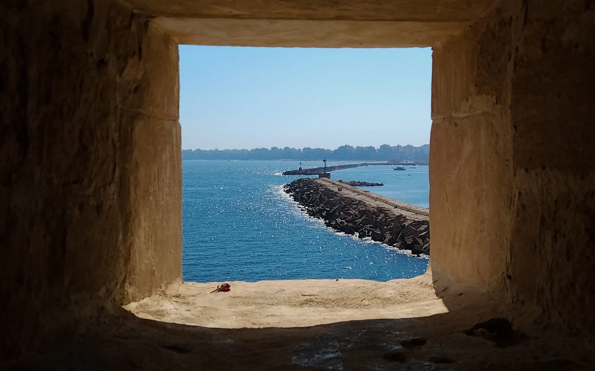 Priveliște spre mare printr-o fereastră istorică din piatră în Alexandria