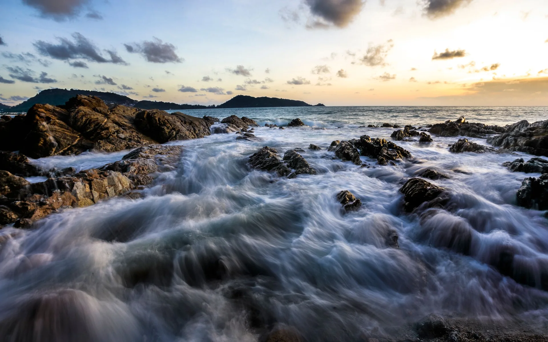 Valuri pe coasta stâncoasă din Phuket la apusul soarelui