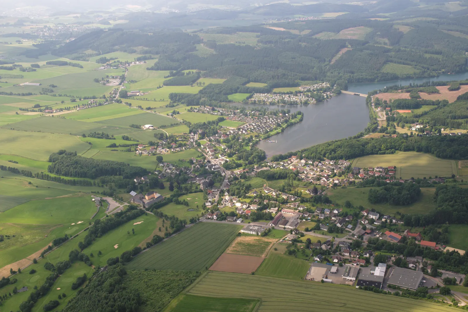 Lacul Sorpesee văzut din aer, cu satul Amecke pe malul său estic și dealurile împădurite din Sauerland care îl înconjoară